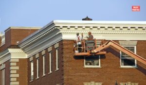 A Group Of Men On A Platform On A Building