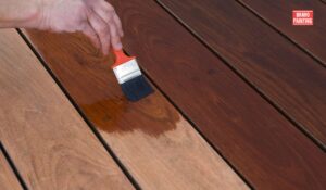 A Person Painting A Deck