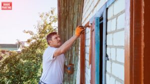 A Man Painting A Window
