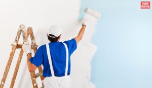 A Man Painting A Wall