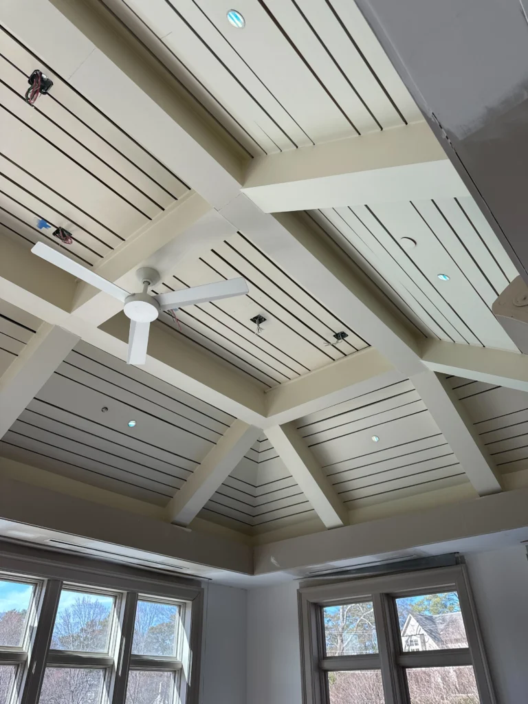 a ceiling fan and windows in a room