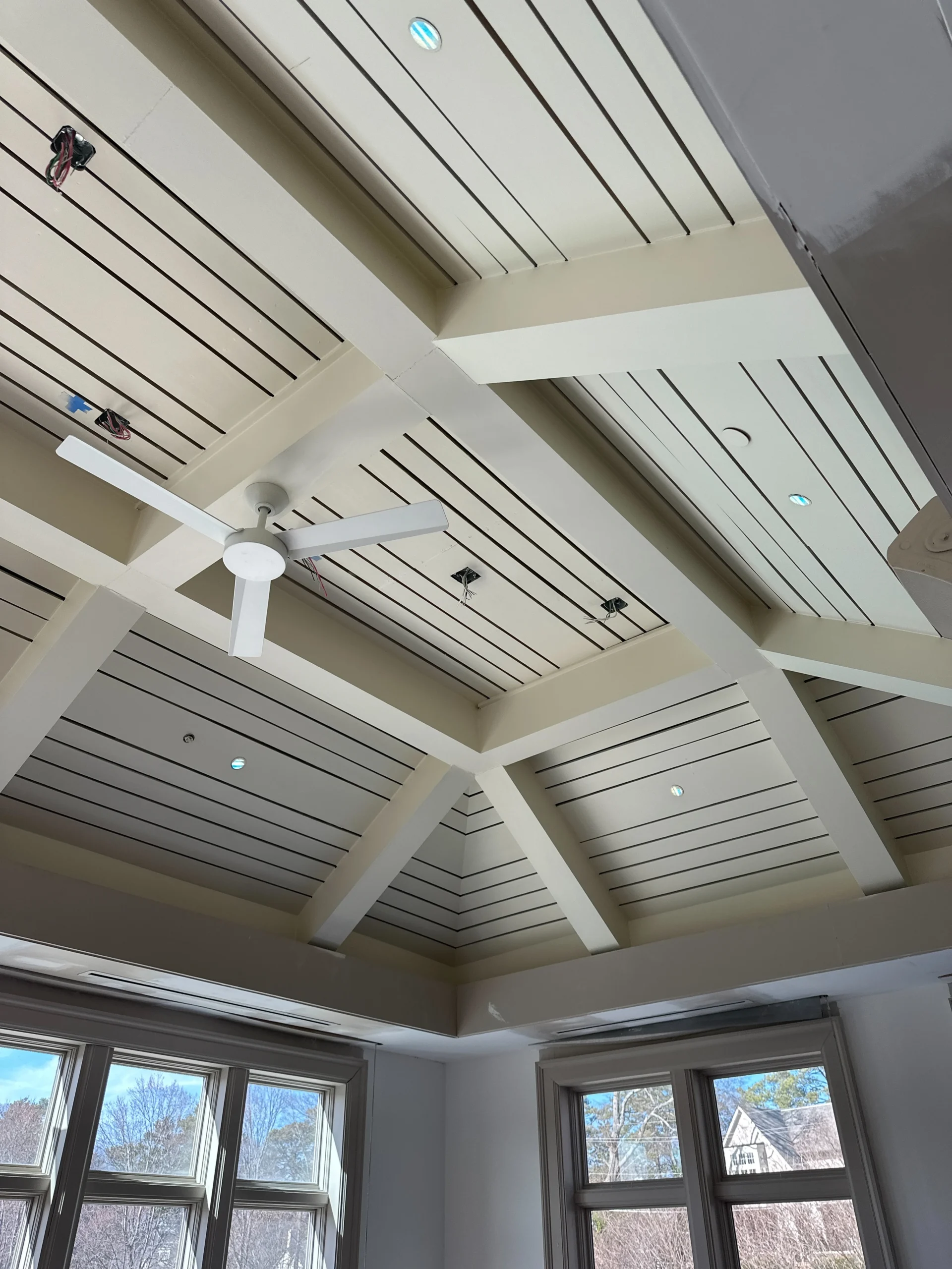 a ceiling fan and windows in a room