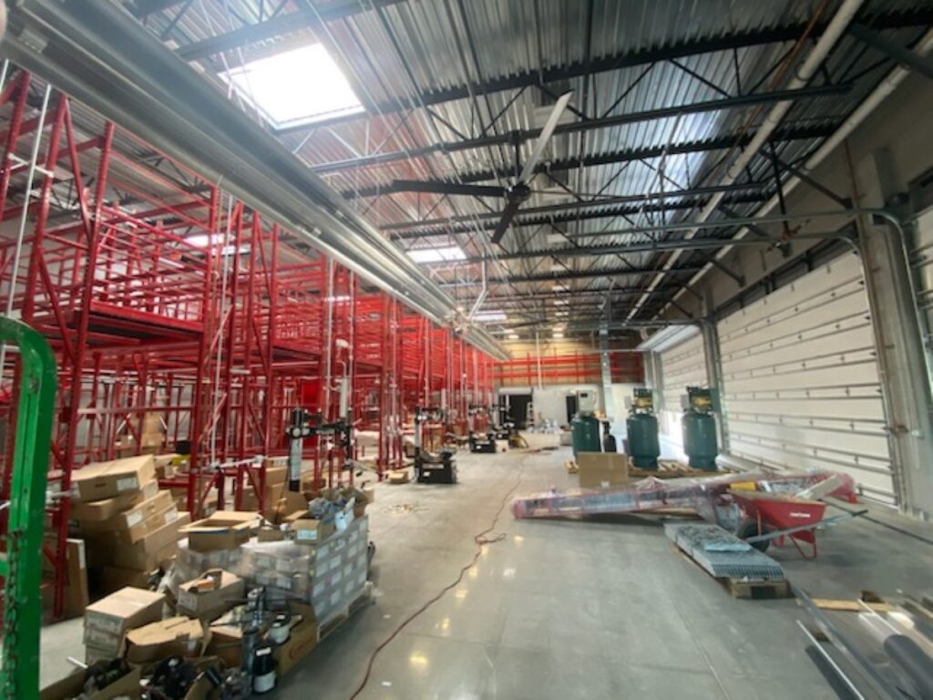 a warehouse with red metal pipes and boxes