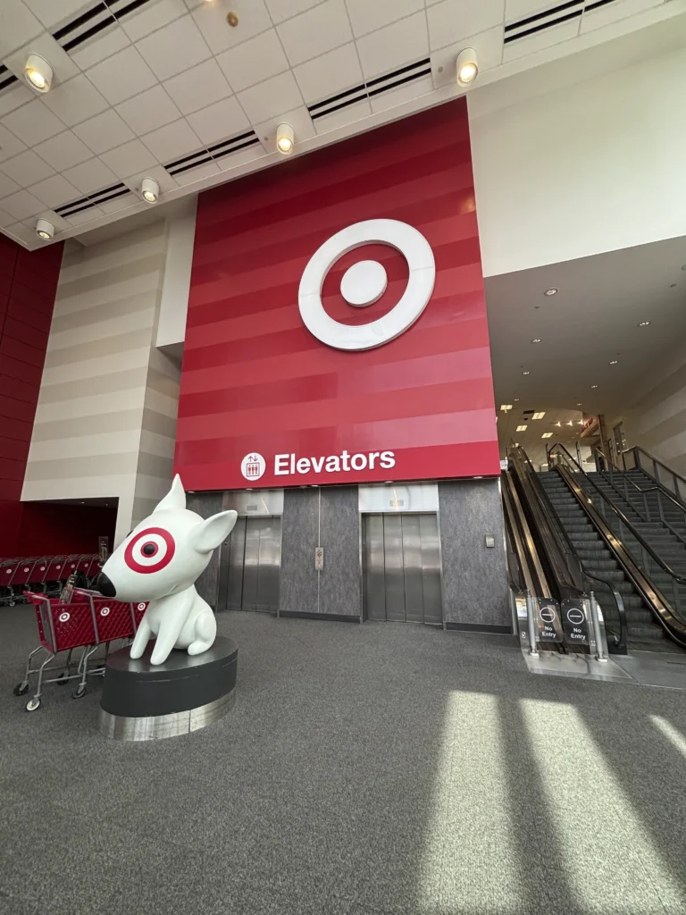 a red and white sign with a dog statue in front of a red and white sign
