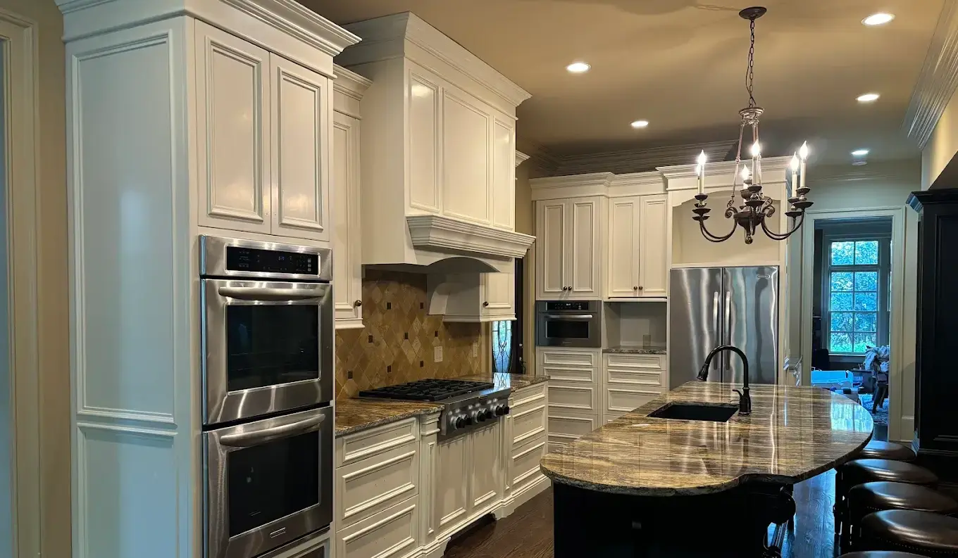 a kitchen with white cabinets and a chandelier
